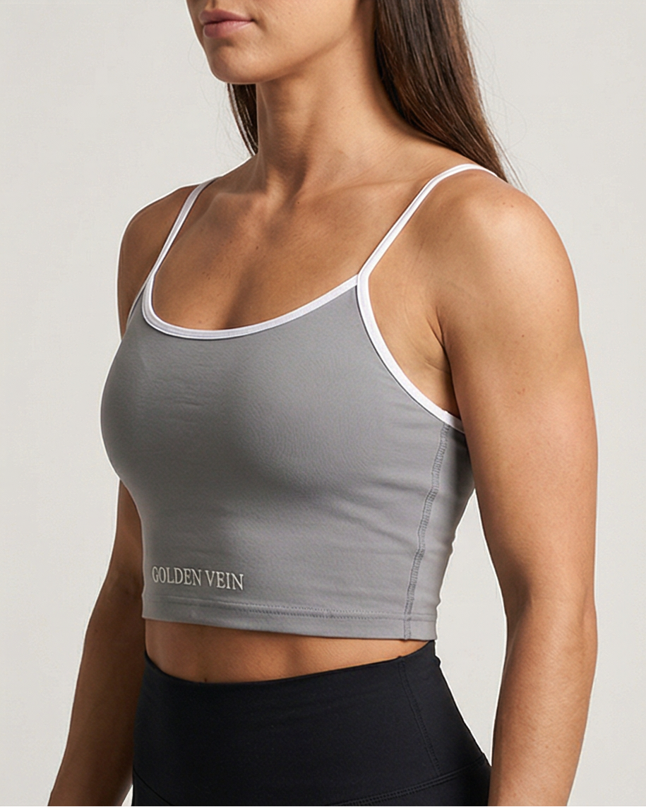 Schwarzes Golden Vein Essential Crop Top aus weichem Stretchmaterial, getragen von einem sportlichen weiblichen Model in Studioaufnahme; klare Silhouette und minimalistisches Design. 45 Grad Ansicht.