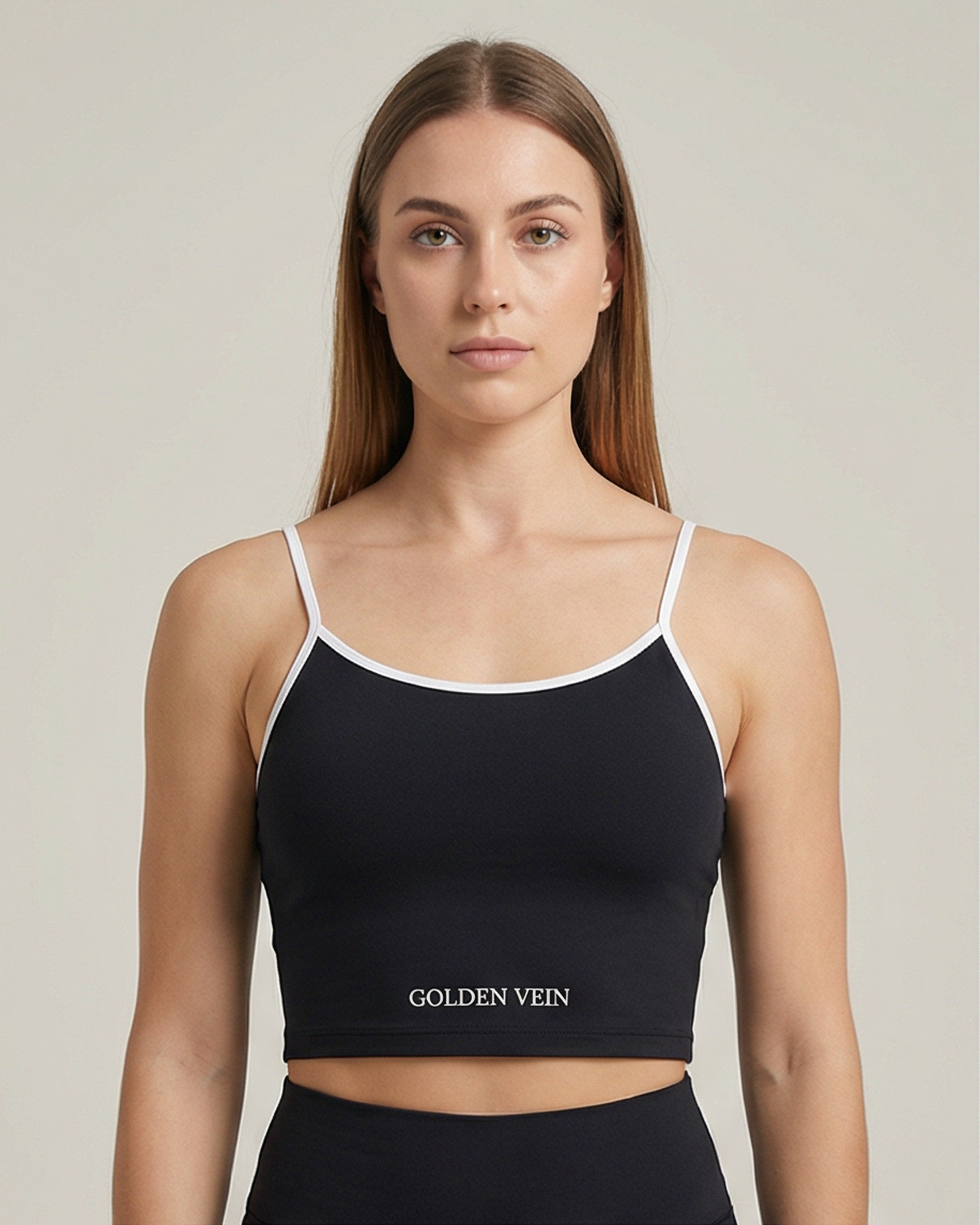 Schwarzes Golden Vein Essential Crop Top aus weichem Stretchmaterial, getragen von einem sportlichen weiblichen Model in Studioaufnahme; klare Silhouette und minimalistisches Design. Front Sicht mit Logo.