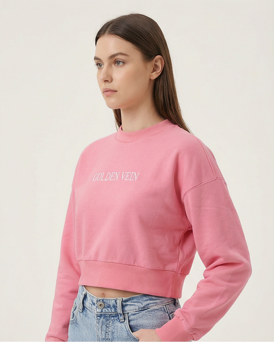 Pinker Golden Vein Cropped Sweater, 45-Grad-Ansicht eines sportlichen weiblichen Models im Studio; moderner, lässiger Athleisure-Look.