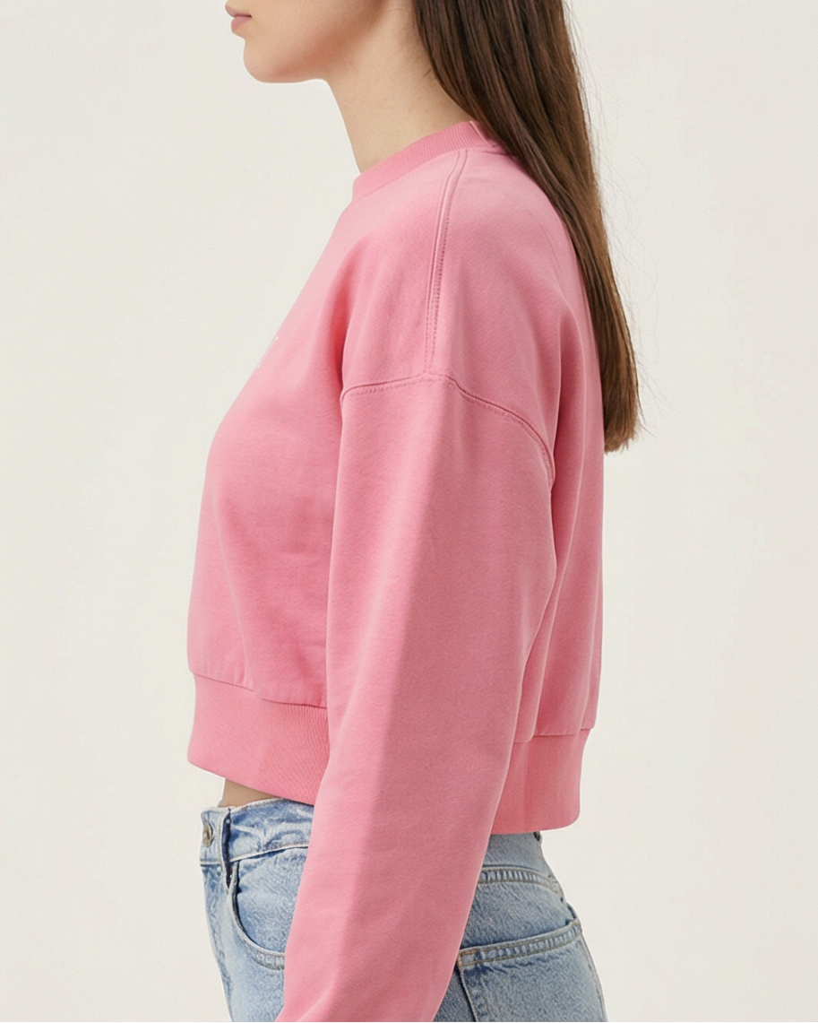 Pinker Golden Vein Cropped Sweater, seitliche Studioansicht eines weiblichen Models; Fokus auf Silhouette, Ärmelstruktur und cropped Länge.