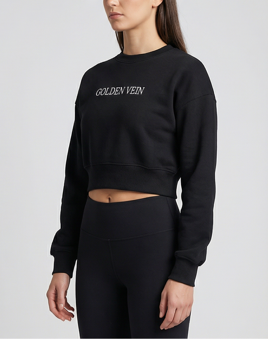 Schwarzer Golden Vein Cropped Sweater, 45-Grad-Ansicht eines sportlichen weiblichen Models im Studio; moderner, klarer Athleisure-Look.