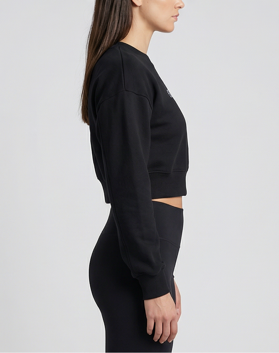 Schwarzer Golden Vein Cropped Sweater, seitliche Studioansicht eines weiblichen Models; Fokus auf cropped Länge, Silhouette und Ärmelstruktur.