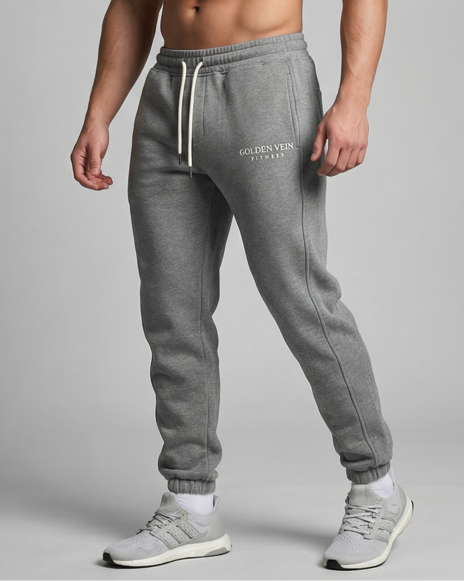 Graue GV Essential Sweatpants, 45-Grad-Ansicht eines sportlichen männlichen Models im Studio; athletische Passform und moderner Athleisure-Look.