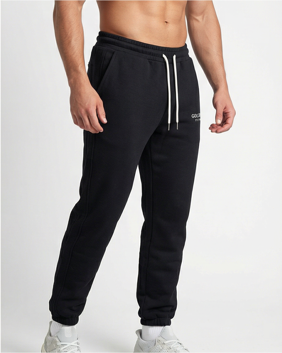 Schwarze GV Essential Sweatpants, 45-Grad-Ansicht eines sportlichen männlichen Models im Studio; athletische Passform und moderner Athleisure-Look.
