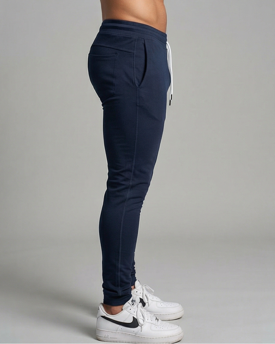 GV Performance Jogger in Navy, seitliche Ansicht eines männlichen Models im Studio; Fokus auf Silhouette, Seitennaht und Schnitt.