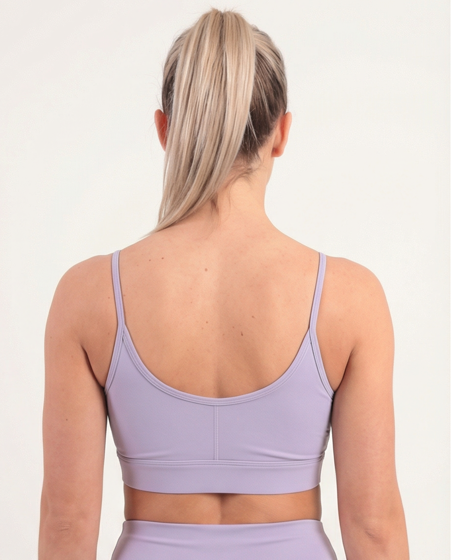 Lavendelfarbener Golden Vein Performance Sports Bra, Rückansicht an weiblichem Fitness-Model; detaillierte Trägerführung und glatter Materialverlauf.