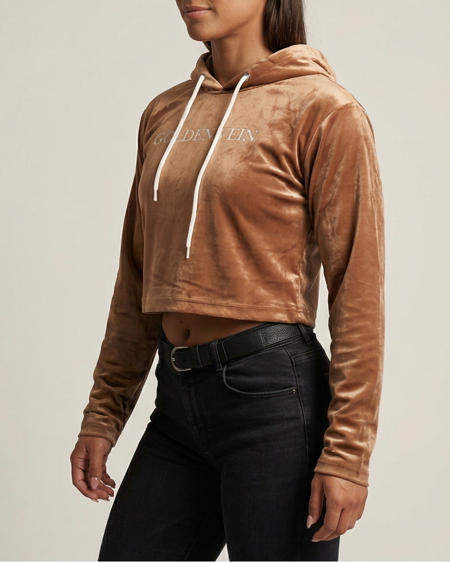 Golden Vein Velvet Cropped Hoodie in karamellbraun, 45-Grad-Ansicht eines sportlichen weiblichen Models im Studio; luxuriöse Samtoptik und moderner Athleisure-Look.