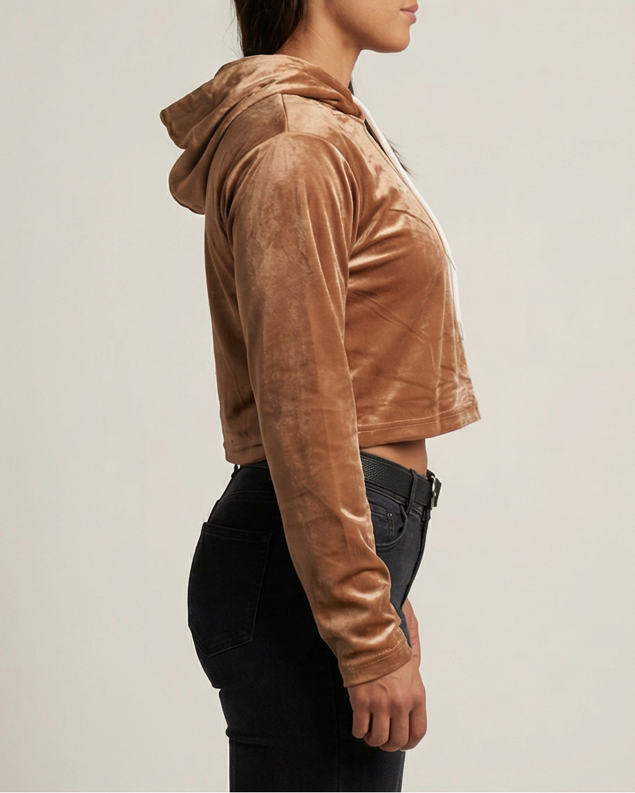 Golden Vein Velvet Cropped Hoodie in karamellbraun, seitliche Studioansicht eines weiblichen Models; Fokus auf Samtstruktur, Ärmelvolumen und cropped Länge.